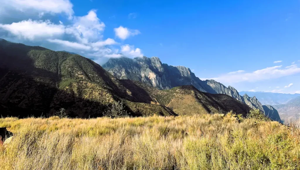 From Megacities to the Highlands | Small Group Tour mountain in yunnan under a blue sky