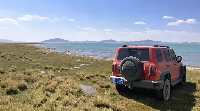 Travel Guide to Tibet jeep on tibetan lake shore e1768304281246