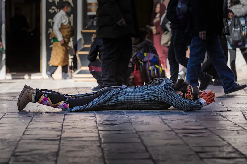 Travel Guide to Tibet pilgrim praying in lhasa